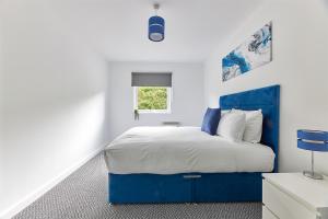 a bedroom with a blue bed and a window at Low Lights - Properties Unique in North Shields