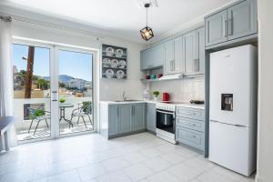a kitchen with blue cabinets and a view of a patio at Lilis Apartment 3 in Karpathos