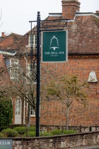 a sign for the bell inn in front of a brick building at The Bell Inn Hotel in Lyndhurst