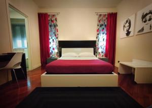 フロジノーネにあるHotel L' Orto degli Otelliのベッドルーム1室(赤いカーテン付きの大型ベッド1台付)