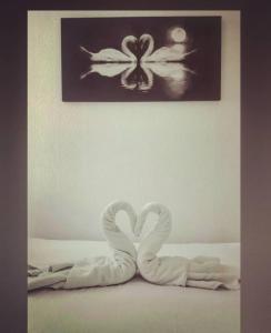 dos cisnes de toalla sentados en una cama bajo una foto en Relax Inn Guest House, en Brighton & Hove