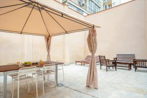 a patio with a table and chairs and umbrellas at Inside Barcelona Apartments Salva in Barcelona