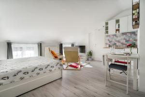 a bedroom with a bed and a desk and a table at Sweet Loft Apartment (White) in Rijeka center in Rijeka