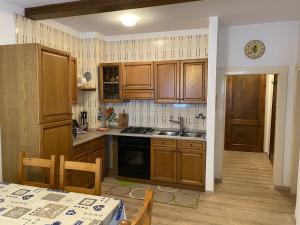 een keuken met houten kasten, een wastafel en een tafel bij Trilocale 020 Pinzolo in Pinzolo