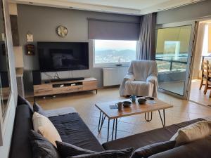 un soggiorno con divano e TV di ''Stergiou Luxury Apartment 2nd Floor'' με κοινη πισινα a Saronida