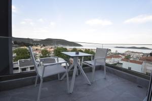 einen Tisch und Stühle auf einem Balkon mit Aussicht in der Unterkunft ELYSIUM STUDIOS in Néa Péramos