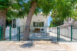 a green fence with a tree in front of a house at Spacious 3-Bedroom House in Larnaca in Larnaca
