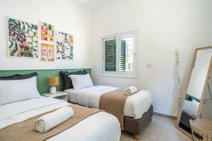 Habitación con 2 camas y ventana en Spacious 3-Bedroom House in Larnaca en Lárnaca