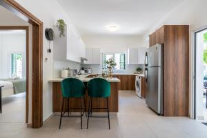 a kitchen with white cabinets and green bar stools at Arty Haven - Spacious 3-BR House in Larnaca in Larnaka