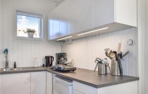 a kitchen with white cabinets and a counter top at Stunning Apartment In Sölvesborg in Sölvesborg