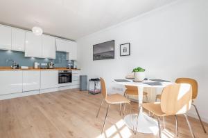a kitchen with white cabinets and a table and chairs at Abbey Street - 2 bedroom - Central in St. Andrews