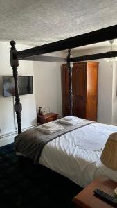 a bedroom with a large bed with a wooden frame at Old Court Hotel & Apartments in Symonds Yat