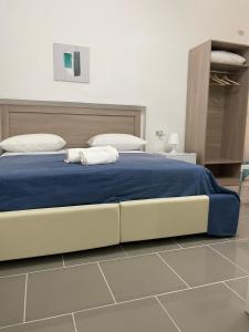 1 dormitorio con 1 cama grande con sábanas y almohadas azules en B&B House of Sun, en Villapiana