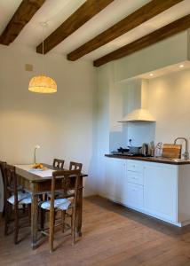 Alloggio Sole في Faedis: مطبخ مع طاولة خشبية وغرفة طعام