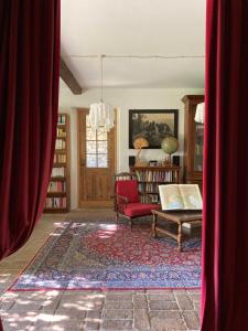 Alloggio Sole في Faedis: غرفة معيشة مع أريكة وكرسي احمر