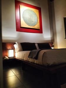 a bedroom with a bed with a painting on the wall at Hotel L' Orto degli Otelli in Frosinone