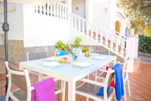a white table and chairs on a patio at Villa Ohana by Sonne Villas in Cala Galdana