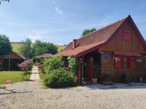 un pequeño edificio de madera con techo rojo en Pod orehom drvena kuća i sauna en Krapina