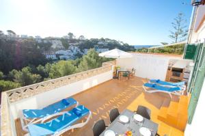 einen Balkon mit blauen Stühlen sowie einem Tisch und Stühlen in der Unterkunft Can Tomeu by Sonne Villas in Cala Galdana