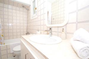 ein weißes Badezimmer mit Waschbecken und Spiegel in der Unterkunft Can Tomeu by Sonne Villas in Cala Galdana + 46 Fotos