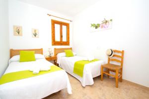 ein Zimmer mit 2 Betten und einem Stuhl darin in der Unterkunft Can Tomeu by Sonne Villas in Cala Galdana