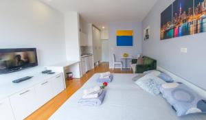 ein Wohnzimmer mit einem Sofa und einem TV in der Unterkunft Apartment Sun in Mostar