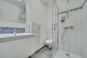 La salle de bains blanche est pourvue d'une douche et de toilettes. dans l'établissement SWEET ANGEL Suite romantique avec SPA, à Bruz