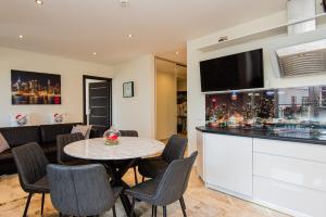 a dining room with a table and a television at Perliukas in Palanga