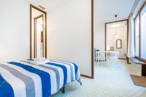 a bedroom with a bed with a blue and white striped blanket at San Vicente 31 Old Town in Benidorm
