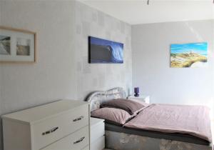 um quarto com uma cama com uma cómoda branca e uma cama quadrada em Lro em Stäbelow