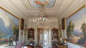 Habitación con pinturas en el techo y lámpara de araña. en camere in Villa d'epoca en Abbazia di Santa Maria in Selva