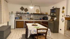 a kitchen with a table with chairs and a refrigerator at La Casa di Stefania in Porto Pino +18 photos