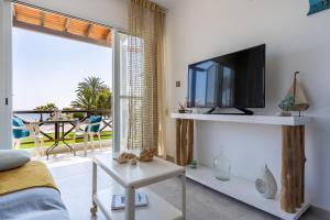 a living room with a tv and a balcony at 1- Bedroom Apartment near Meneou Beach in Larnaka