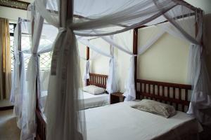 Un pat sau paturi într-o cameră la Immaculate 2-Bedroom Cottage in Kampala