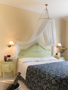 a bedroom with a bed with a canopy at Hotel Panorama Ristorante ***S in Torri del Benaco