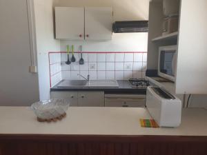 a kitchen with white cabinets and a counter top at Anais location 971 Guadeloupe in Le Gosier