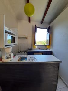 a kitchen with a counter top and a window at Anais location le soleil couchant in Le Gosier