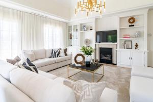 un soggiorno bianco con divano bianco e camino di CLN- Spacious 6 bedroom villa next to beach a Marbella