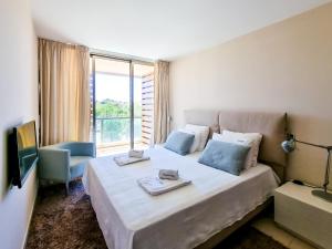 1 dormitorio con cama grande y ventana grande en FLH Salgados Family Apartment en Guia