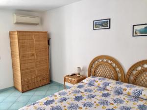um quarto com uma cama e um armário de madeira em Vento di Terra Ponza em Ponza