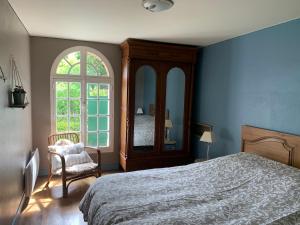 een slaapkamer met een bed, een stoel en een raam bij Le Havre de Braye in Braye-en-Laonnois