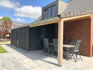 a patio with a building with a table and chairs at Bungalow 74 op Recreatiepark De Wielen in Sint Maarten