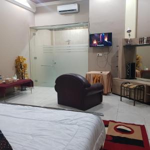 a bedroom with a bed and a sliding glass door at Rezka Roomz Syari'ah in Ende