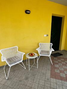 dos sillas y una mesa frente a una pared amarilla en Casa Sergio, en Colonnella