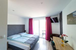 a bedroom with a bed and a window with red curtains at Apartamenty HELJAN in Międzywodzie