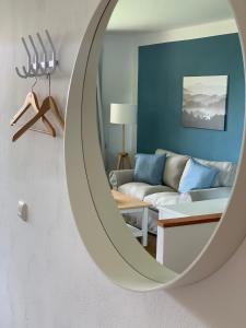 a mirror in a living room with a couch at Landhaus Tipp in Altenmedingen