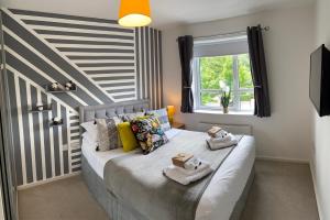 a bedroom with a bed with two towels on it at Detached riverside Villa in the heart of Manchester in Manchester