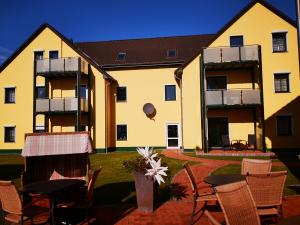 a large yellow building with chairs and a table at Schlechters Feriendomizil in Zinnowitz