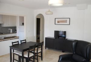 sala de estar con mesa y sillas y cocina en Lovely apartment near Golf, en Orihuela