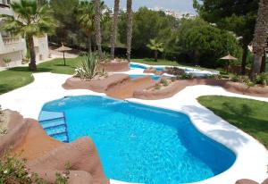 einen Pool mit blauem Wasser in einem Resort in der Unterkunft Lovely apartment near Golf in Orihuela